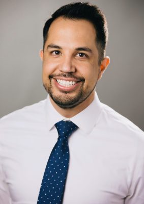 Photo of faculty affiliate Ray Moody, a man with a white shirt and blue tie